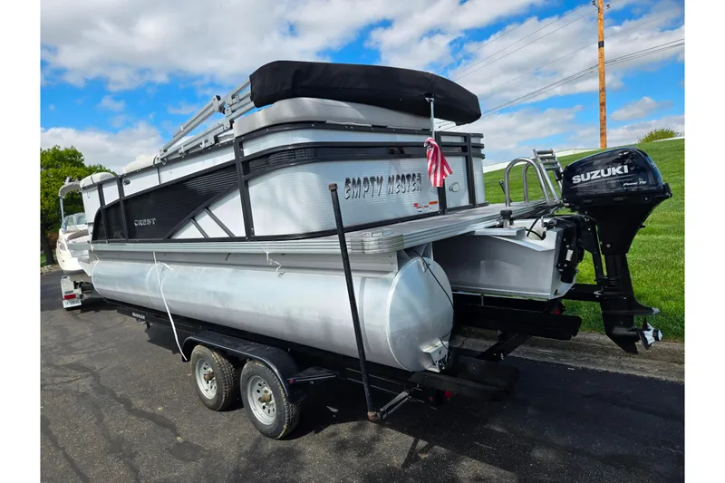 Slide: The Image of 2023 Crest Classic LX 200 pontoon boat with Suzuki outboard motor on trailer. - 3