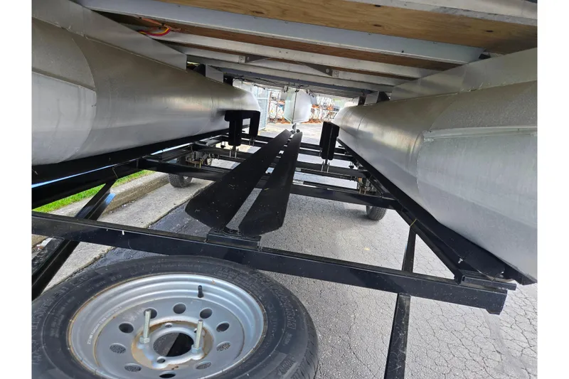 Slide: The Image of Underneath view of a 2023 Crest Classic LX 200 pontoon boat on a trailer. - 7