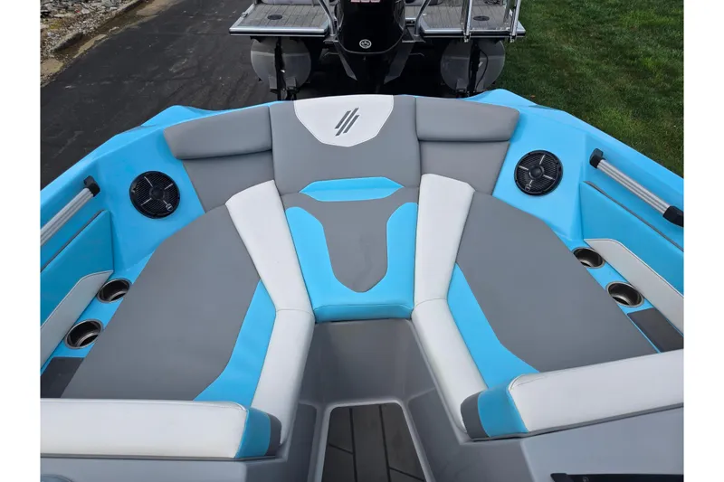 Slide: The Image of 2023 ATX Surf Boats 20 Type-S interior with blue and gray seating, cup holders, and speakers. - 19