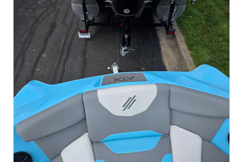 Slide: The Image of 2023 ATX Surf Boats 20 Type-S interior with blue and gray seating, parked on pavement. - 20