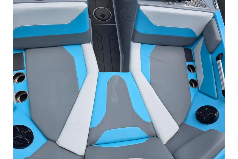Slide: The Image of 2023 ATX Surf Boats 20 Type-S interior with blue and gray seating, cup holders, and speakers. - 21