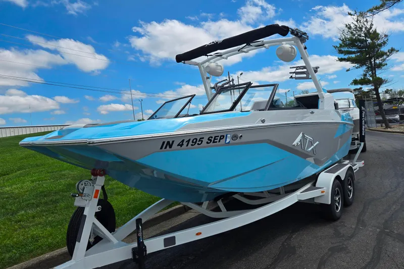 Slide: The Image of 2023 ATX Surf Boats 20 Type-S on trailer, blue and white design, parked outdoors. - 6