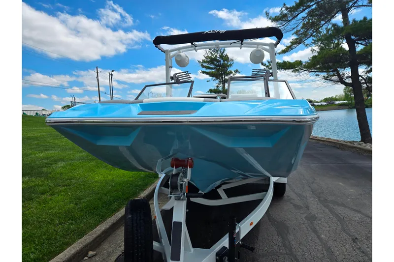 Slide: The Image of 2023 ATX Surf Boats 20 Type-S in blue, parked near a lake under a clear sky. - 7