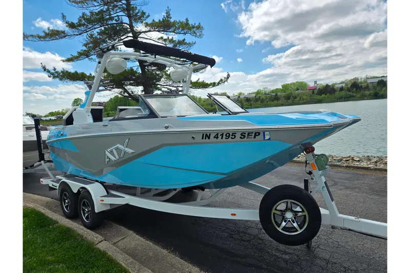 Slide: The Image of 2023 ATX Surf Boats 20 Type-S on trailer by a lake under a cloudy sky. - 9