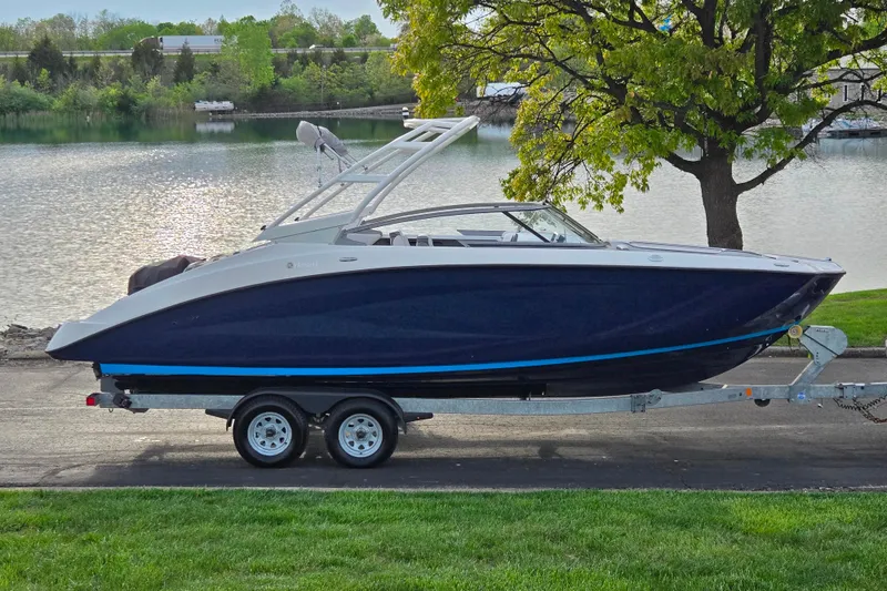 The Image of 2021 Yamaha Boats AR250 on trailer by a scenic lake. - 0