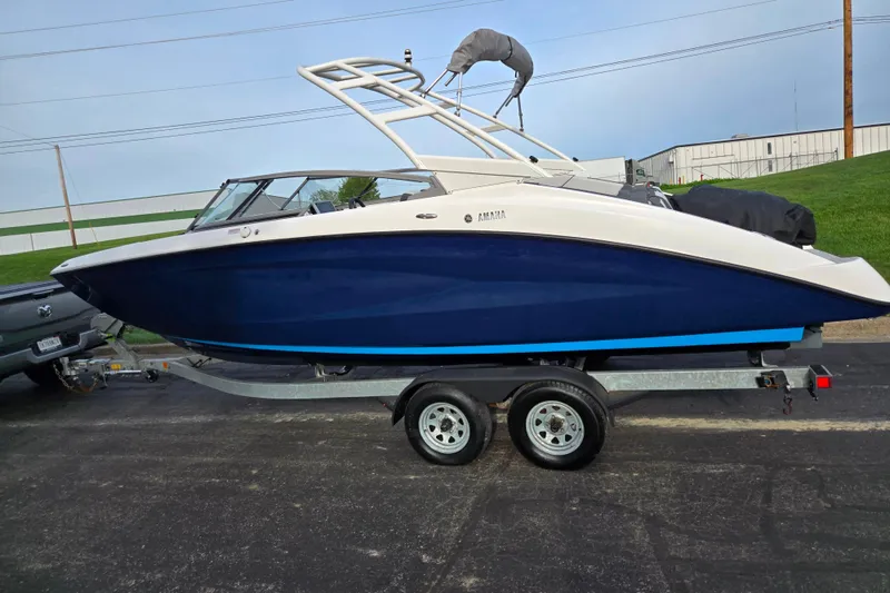 Slide: The Image of 2021 Yamaha Boats AR250 on trailer, blue and white design, parked outdoors. - 4