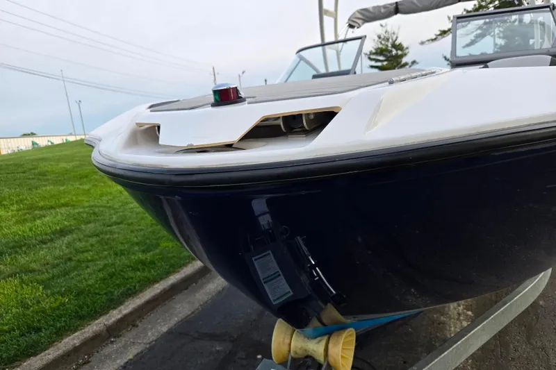 Slide: The Image of 2021 Yamaha Boats AR250 bow view on trailer, parked on grass. - 6