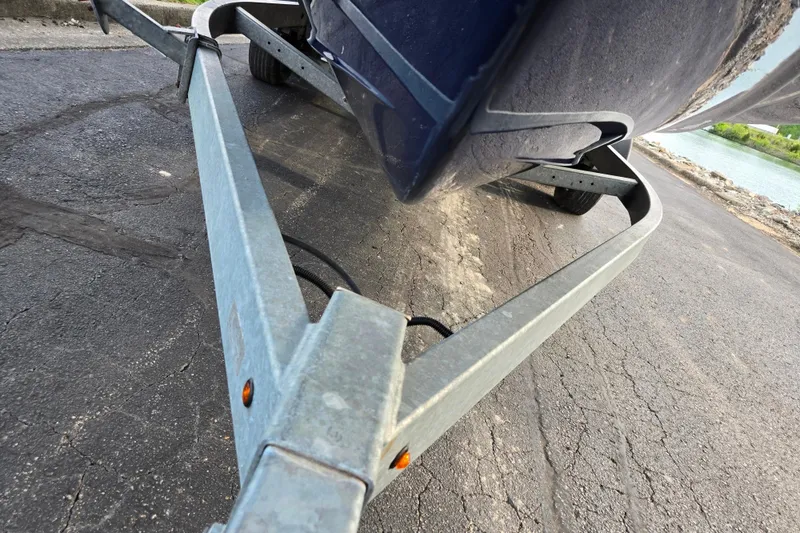 Slide: The Image of Trailer carrying a 2021 Yamaha Boats AR250 on a paved road near water. - 7