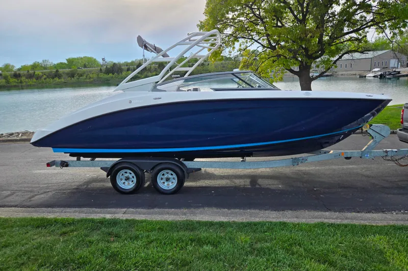 Slide: The Image of 2021 Yamaha Boats AR250 on trailer by a lakeside road. - 9