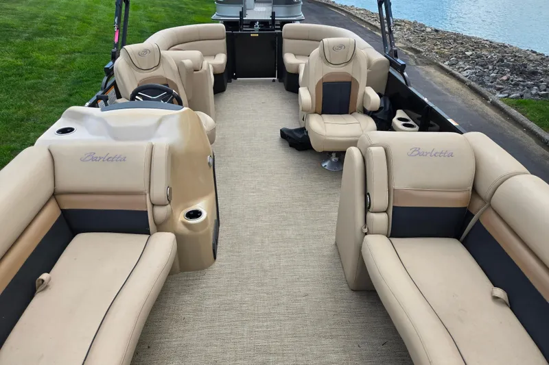 Slide: The Image of 2021 Barletta C22QC pontoon boat interior with beige seating and steering console. - 10