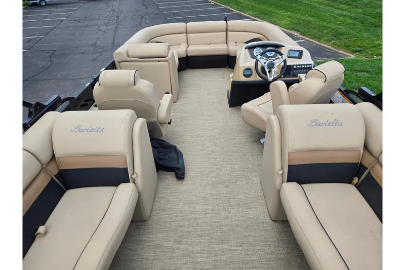 Slide: The Image of 2021 Barletta C22QC pontoon boat interior with beige seating and modern dashboard. - 17
