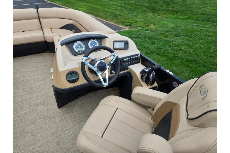 Slide: The Image of 2021 Barletta C22QC boat interior with beige seating and modern dashboard controls. - 18