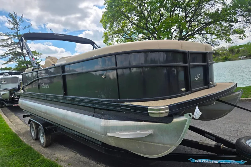 Slide: The Image of 2021 Barletta C22QC pontoon boat on trailer by a lake, under cloudy sky. - 8