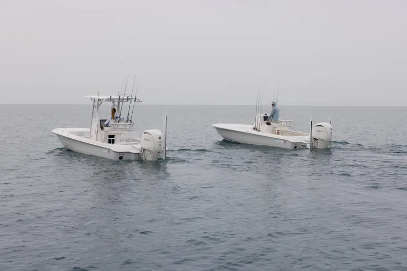Slide: The Image of Two Contender 24 Bay boats on calm ocean waters, 2026 model. - 3