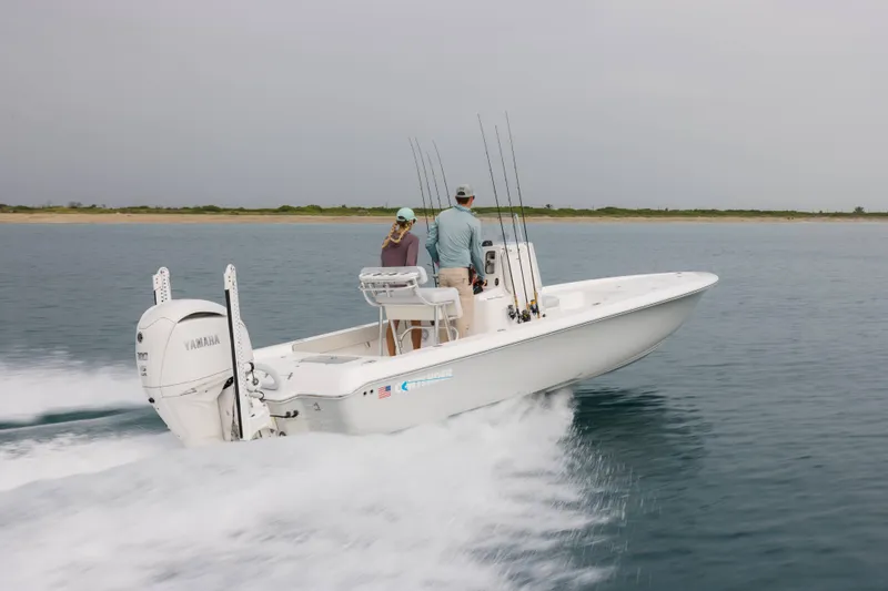 Slide: The Image of 2026 Contender 24 Bay boat cruising on open water with two passengers. - 4