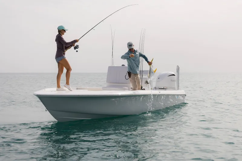 Slide: The Image of Two people fishing on a 2026 Contender 24 Bay boat in open water. - 5