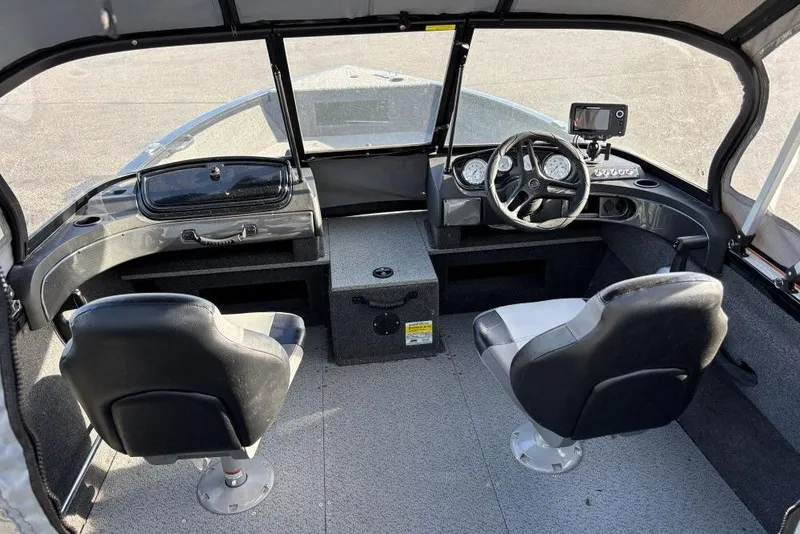 Slide: The Image of 2024 Crestliner 1650 Fish Hawk WT boat interior with steering wheel and seating. - 3