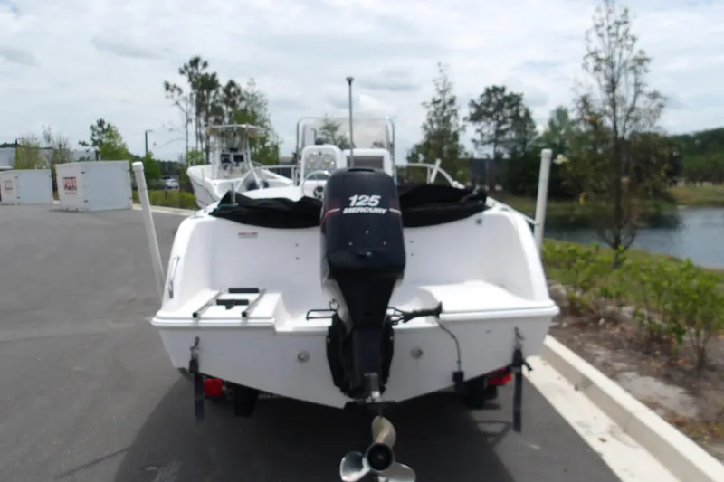 Slide: The Image of 2000 Pro-Line 19 Sport boat with Mercury 125 outboard motor, parked near water. - 10