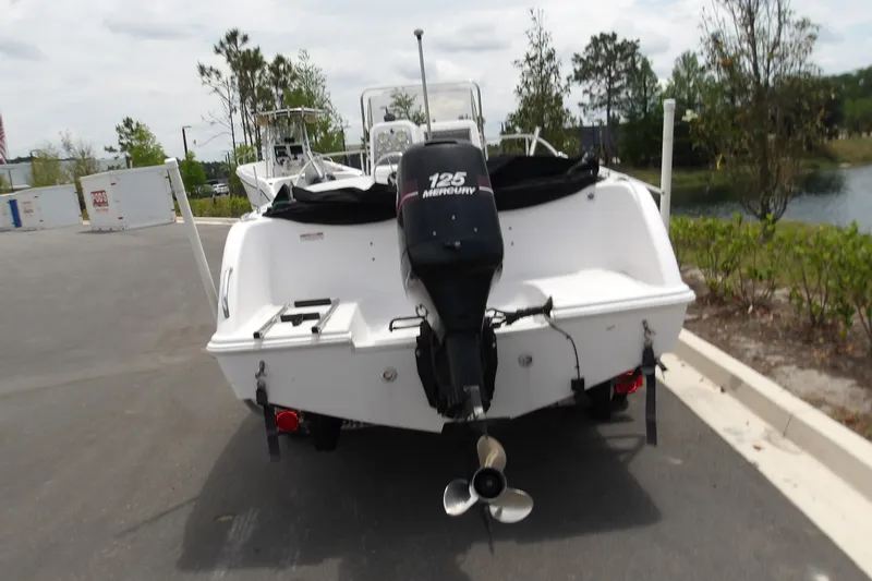 Slide: The Image of 2000 Pro-Line 19 Sport boat with Mercury 125 engine, parked outdoors. - 11