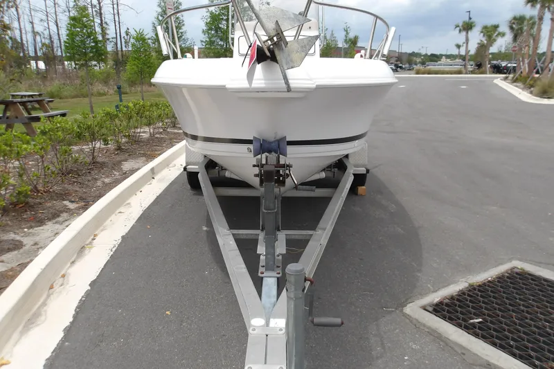 Slide: The Image of 2000 Pro-Line 19 Sport boat on trailer in parking area, surrounded by greenery. - 2
