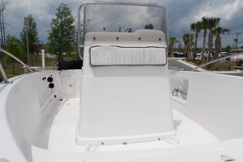 Slide: The Image of 2000 Pro-Line 19 Sport boat interior with console, set against a cloudy sky and palm trees. - 7