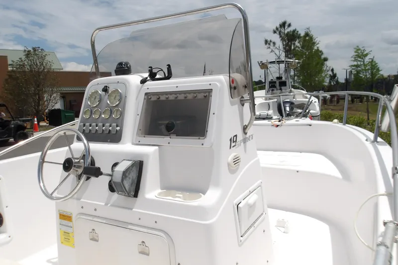 Slide: The Image of 2000 Pro-Line 19 Sport boat dashboard with steering wheel and gauges, outdoors. - 8