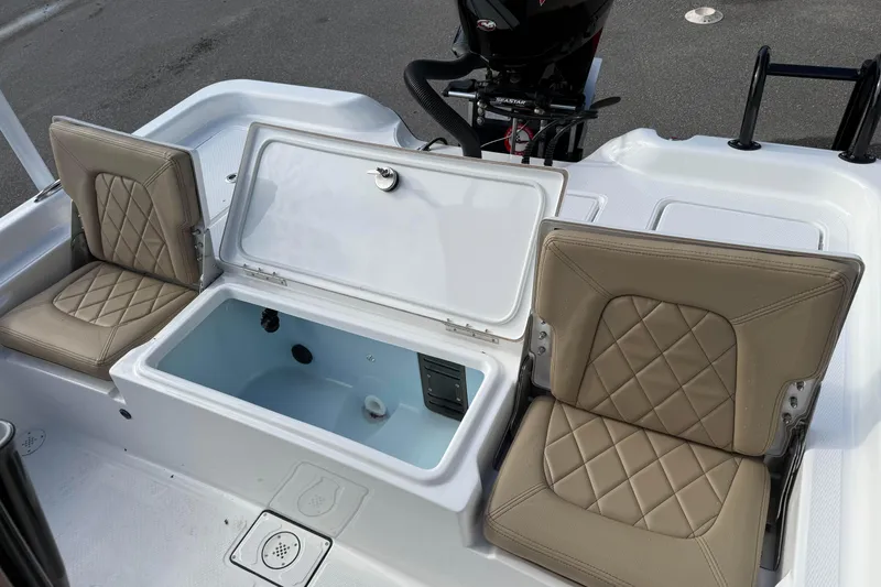 Slide: The Image of 2026 Blazer PureBay 2400 boat interior with open storage compartment and cushioned seats. - 13