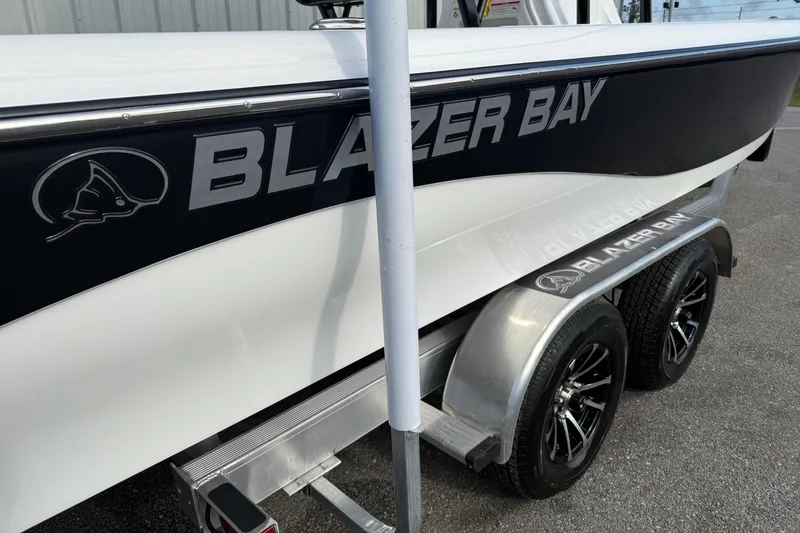 Slide: The Image of 2026 Blazer PureBay 2400 boat on trailer, featuring sleek black and white design. - 4