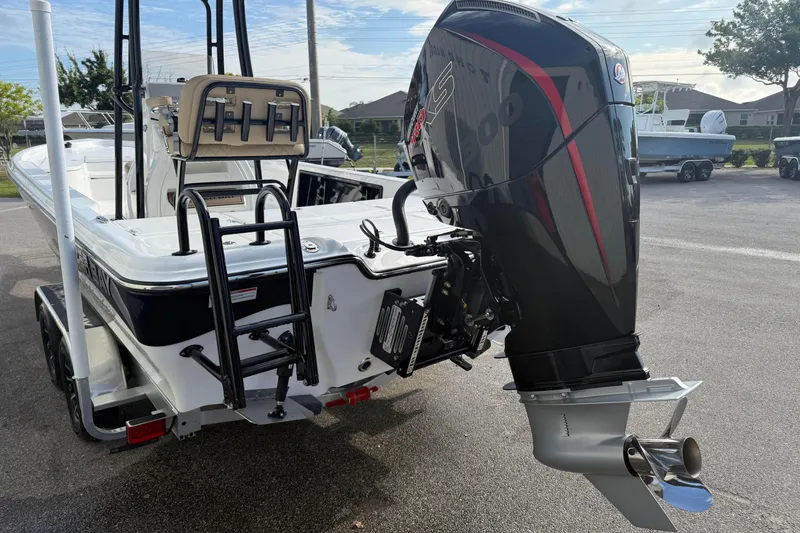 Slide: The Image of 2026 Blazer PureBay 2400 boat with powerful outboard motor, parked on a trailer. - 6