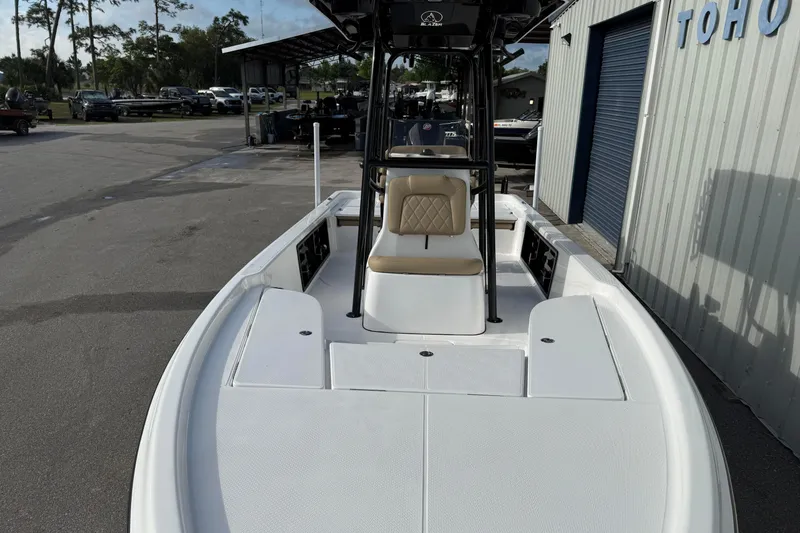 Slide: The Image of 2026 Blazer PureBay 2400 boat, white deck, tan seat, parked near a building. - 8