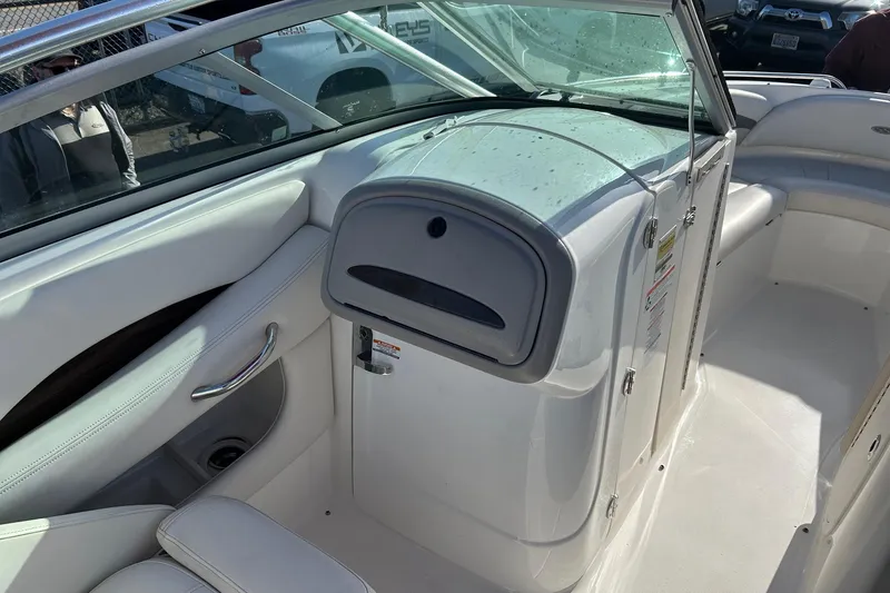 Slide: The Image of 2007 Chaparral 246 SSi boat interior with white seating and storage compartment. - 14