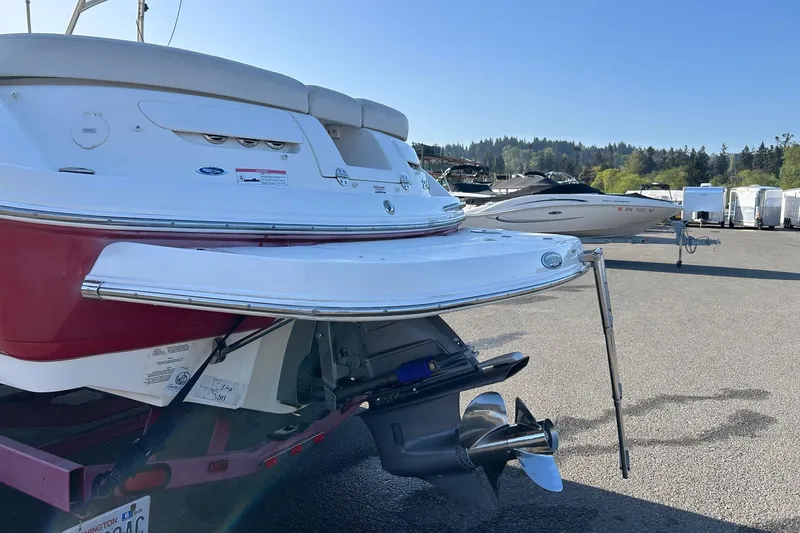 Slide: The Image of 2007 Chaparral 246 SSi boat with red hull, parked on a trailer in a marina. - 4
