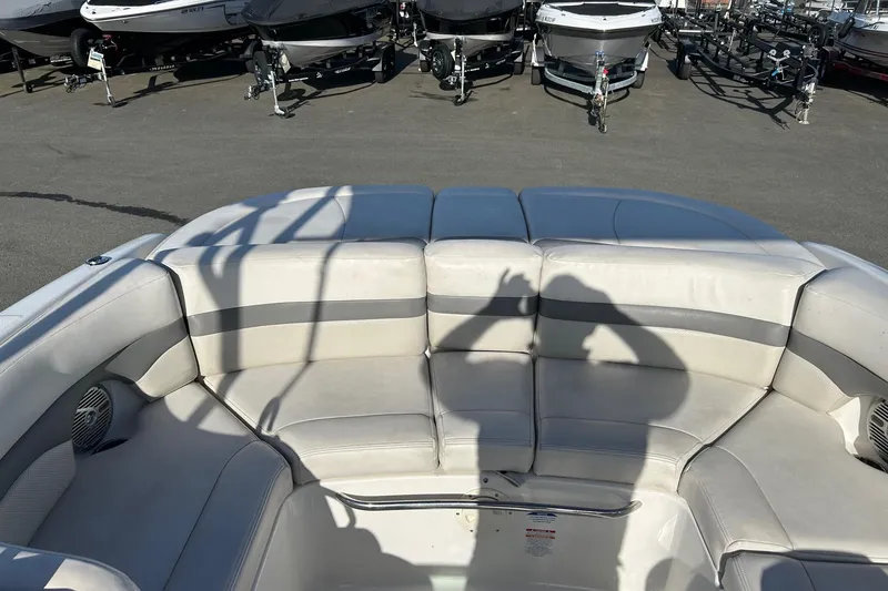 Slide: The Image of 2007 Chaparral 246 SSi boat interior with white seating, parked among other boats. - 8
