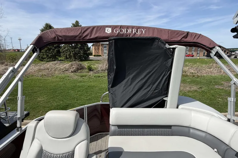 Slide: The Image of 2022 Godfrey Sweetwater 2286 C pontoon boat with canopy, parked on grassy area. - 17