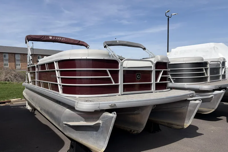 Slide: The Image of 2022 Godfrey Sweetwater 2286 C pontoon boat parked outdoors on a sunny day. - 2