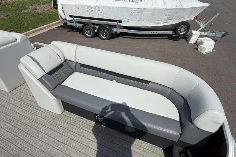 Slide: The Image of 2022 Godfrey Sweetwater 2286 C pontoon boat with gray and white seating, parked on pavement. - 6