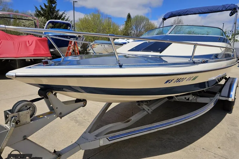 Slide: The Image of 1988 Glastron/Carlson CVX-23 boat on trailer, parked outdoors under blue sky. - 12