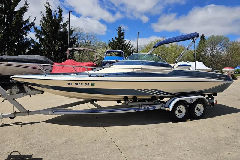Slide: The Image of 1988 Glastron/Carlson CVX-23 boat on trailer, parked outdoors under blue sky. - 14