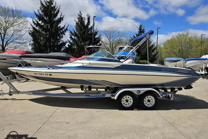 Slide: The Image of 1988 Glastron/Carlson CVX-23 boat on trailer, parked outdoors under a cloudy sky. - 15