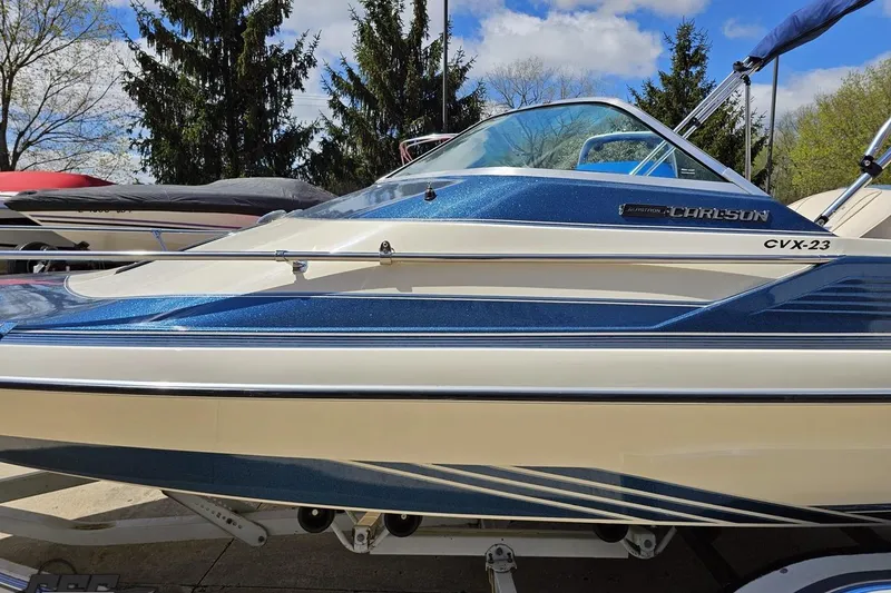 Slide: The Image of 1988 Glastron/Carlson CVX-23 boat with blue and white exterior, parked outdoors. - 16
