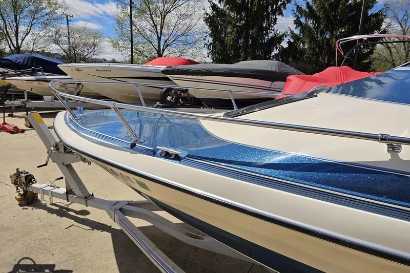 Slide: The Image of 1988 Glastron/Carlson CVX-23 boat on trailer, surrounded by covered boats. - 17
