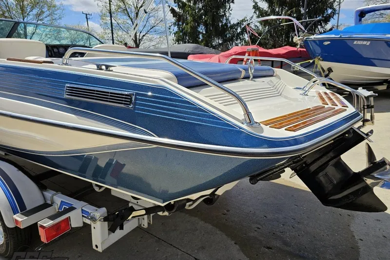 Slide: The Image of 1988 Glastron/Carlson CVX-23 boat with blue and white exterior, displayed outdoors. - 23
