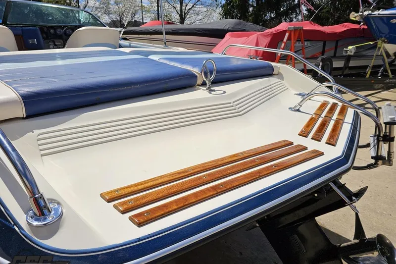 Slide: The Image of 1988 Glastron/Carlson CVX-23 boat with blue upholstery and wooden accents on the deck. - 24