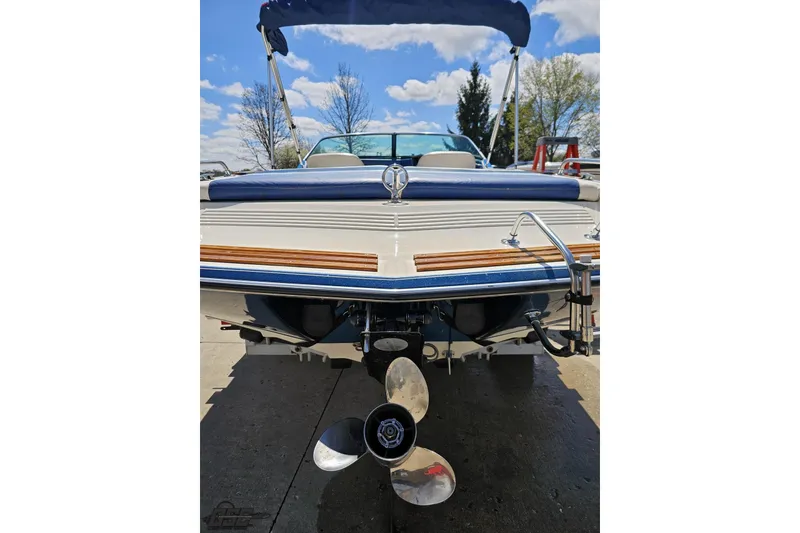 Slide: The Image of 1988 Glastron/Carlson CVX-23 boat rear view with propeller and blue canopy. - 28