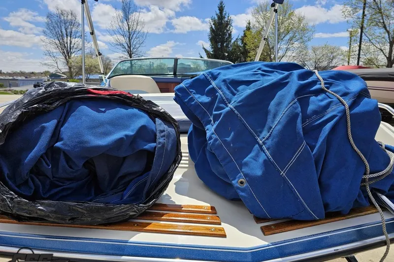 Slide: The Image of 1988 Glastron/Carlson CVX-23 boat with blue covers on deck, sunny day. - 32