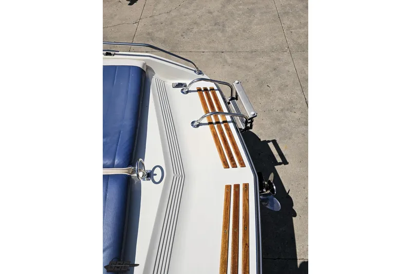 Slide: The Image of 1988 Glastron/Carlson CVX-23 boat with blue seating and wooden deck accents. - 33