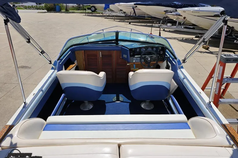 Slide: The Image of 1988 Glastron/Carlson CVX-23 boat interior with blue and white seating, docked outdoors. - 35