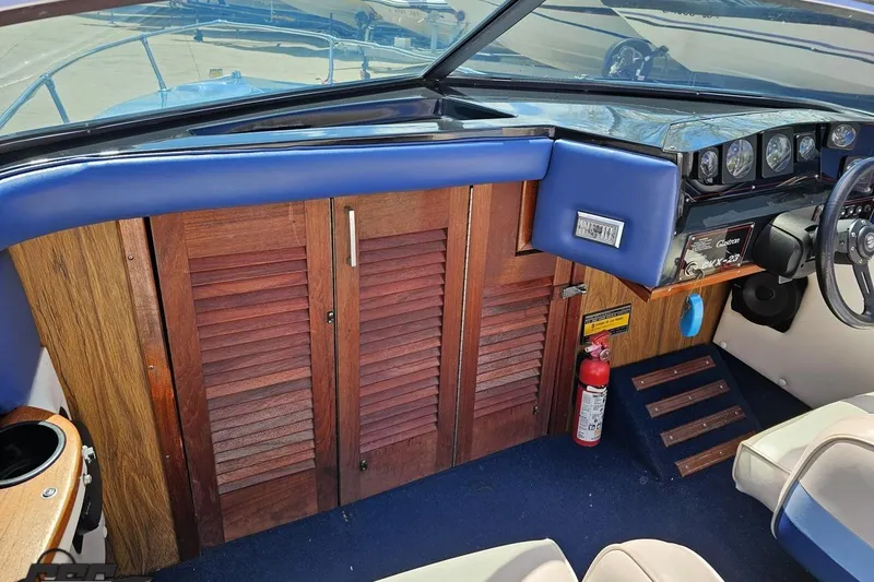 Slide: The Image of 1988 Glastron/Carlson CVX-23 boat interior with wooden cabinetry and blue upholstery. - 48