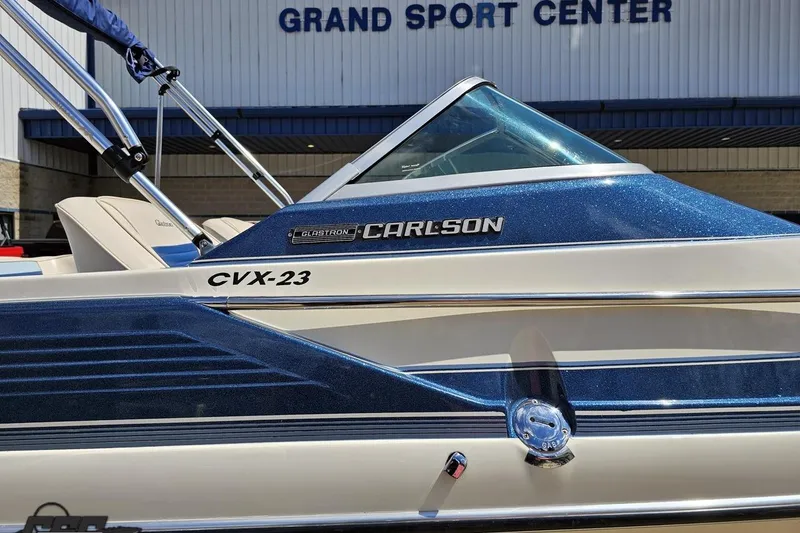 Slide: The Image of 1988 Glastron/Carlson CVX-23 boat at Grand Sport Center, featuring sleek blue and white design. - 5
