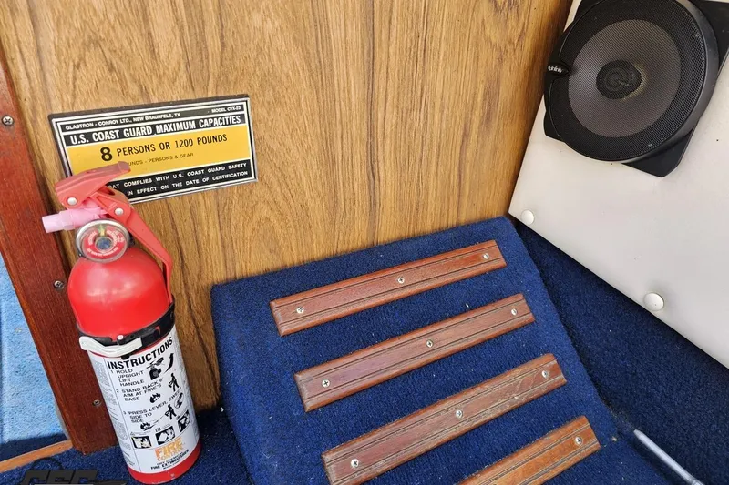 Slide: The Image of 1988 Glastron/Carlson CVX-23 interior with fire extinguisher, speaker, and capacity sign. - 57